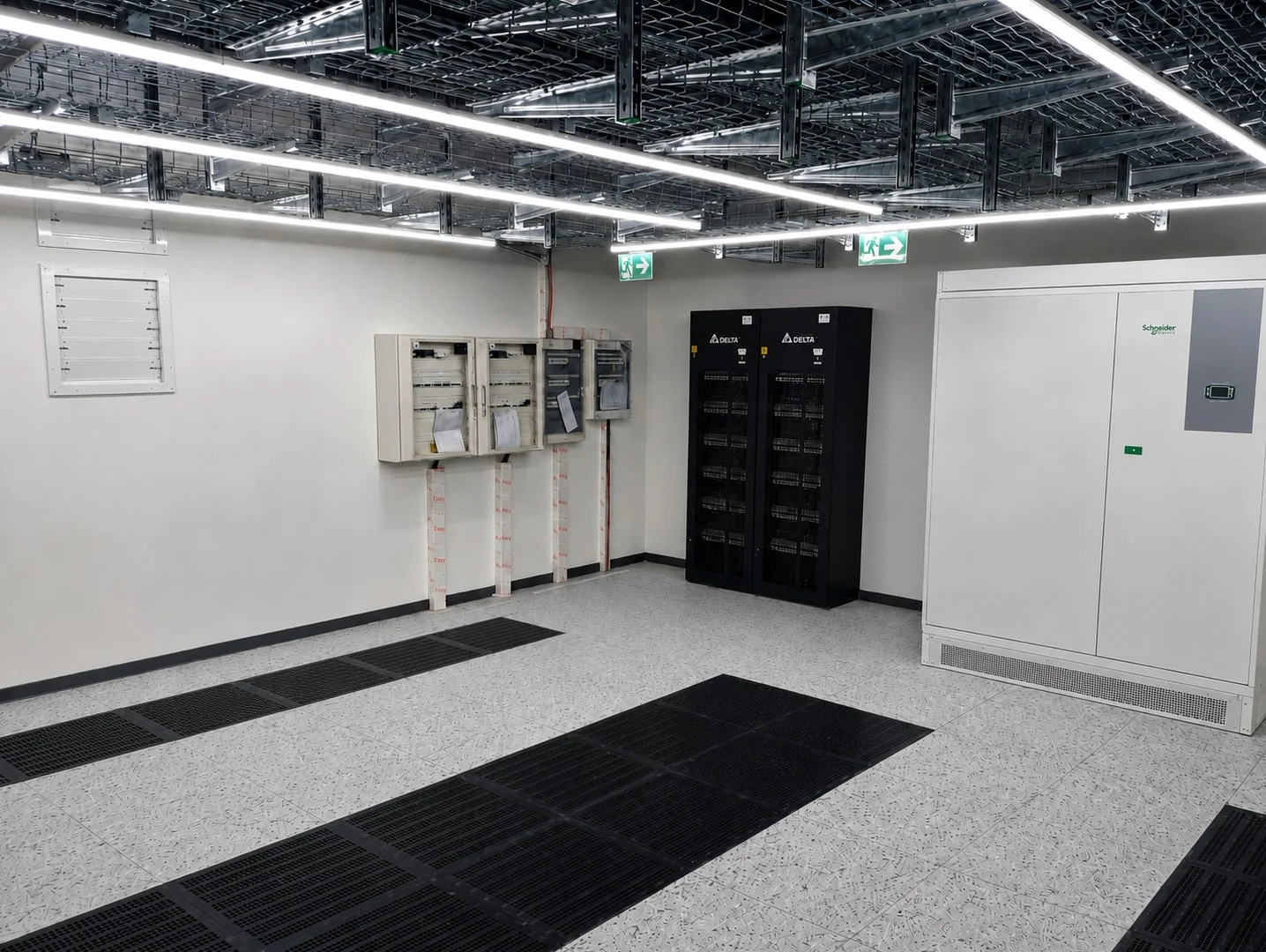 Szünetmentes energiaellátás helyisége akkumulátorszekrénnyel, falra szerelt elosztókkal és rácsos álpadlólapokkal